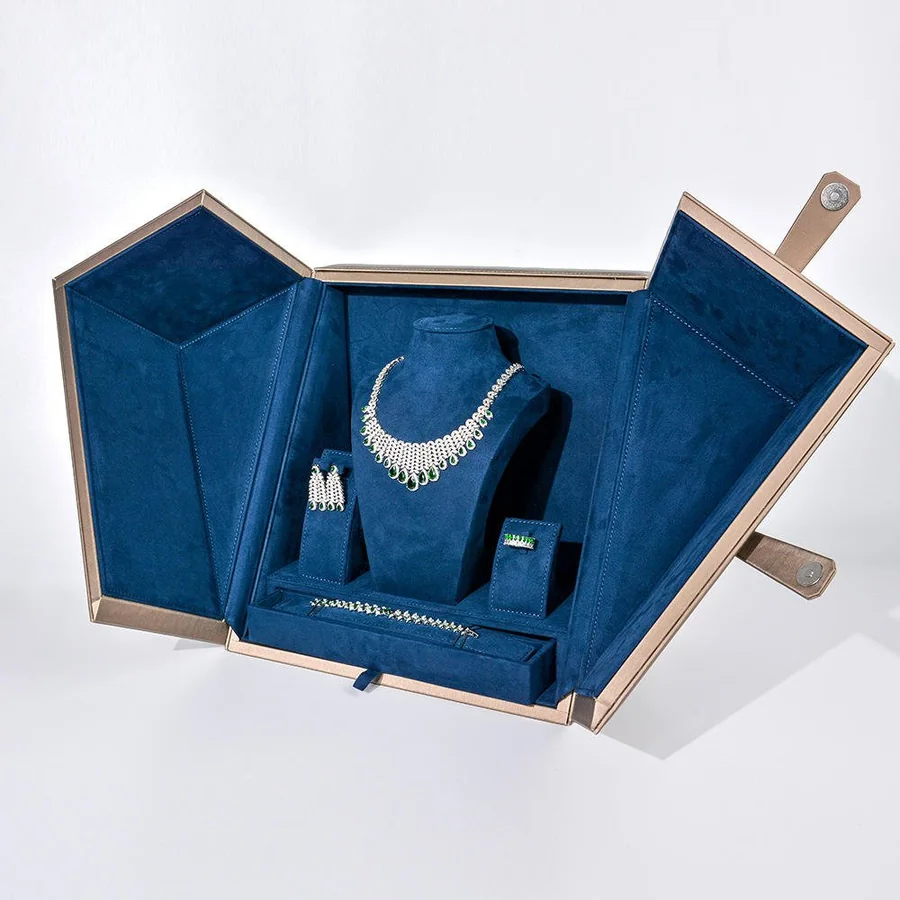 Blue velvet high-end jewelry display box open with a necklace mounted on the lid