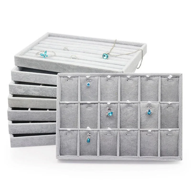 Stacked velvet jewelry display trays with individual ring and earring compartments
